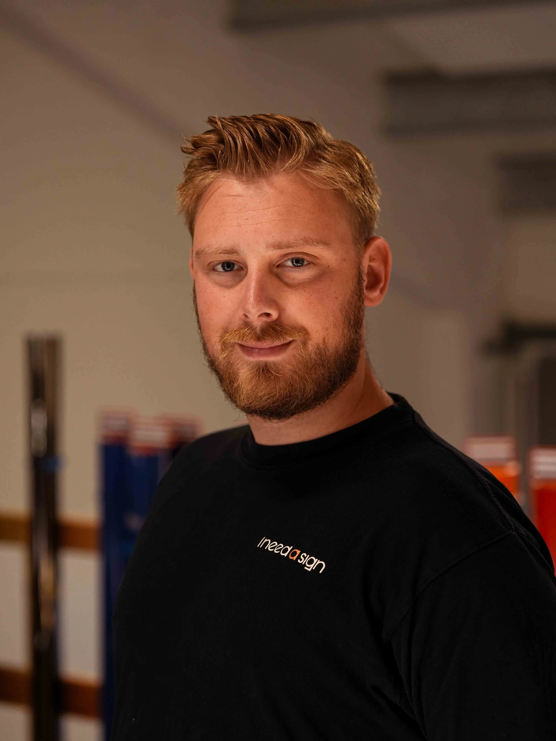 Portræt af Patrick foran reolerne med folieruller