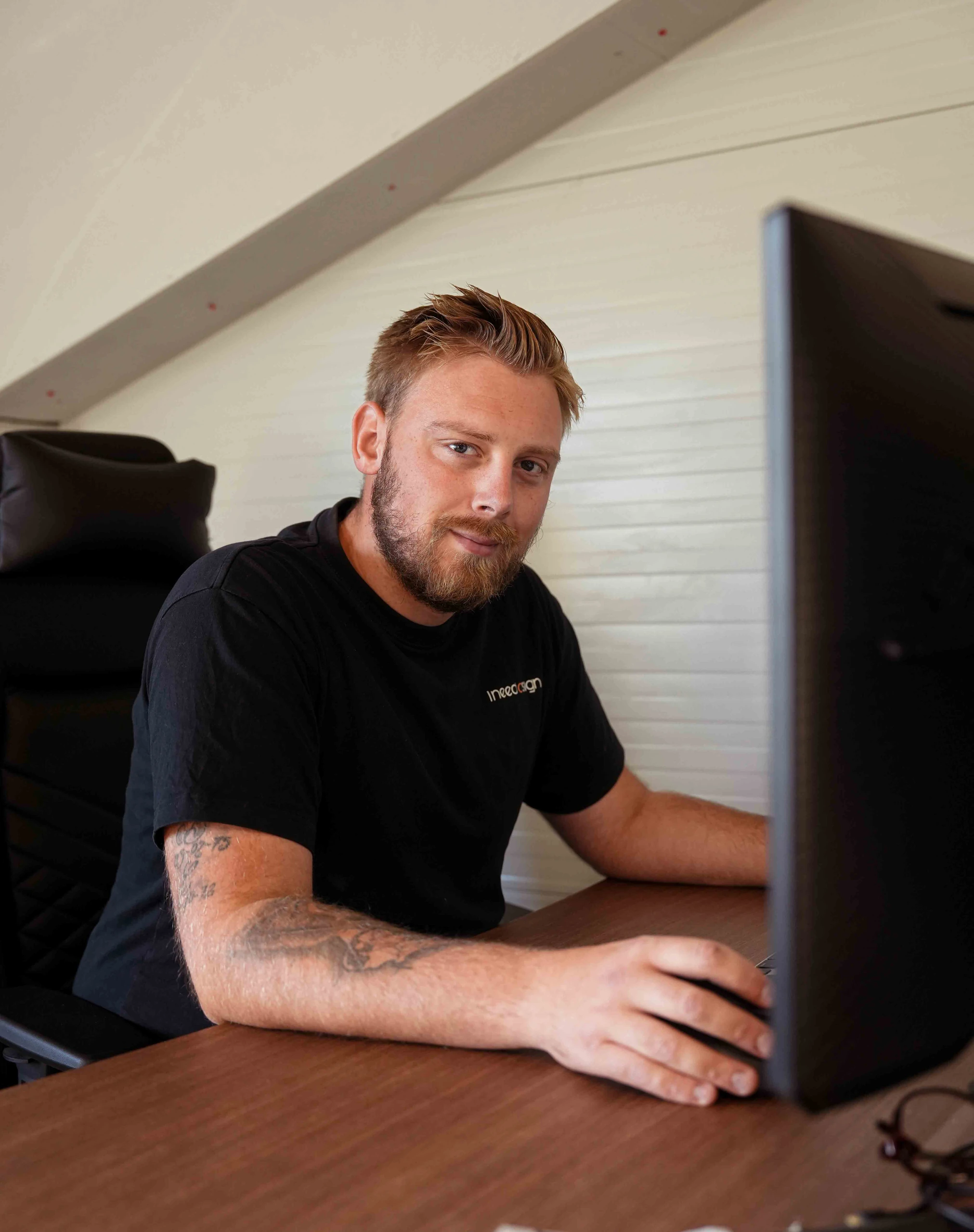 Patrick sidder ved computeren på kontoret og kigger op
