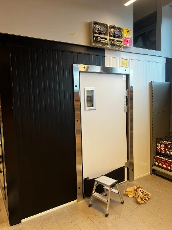 Kølerum-dør i supermarked med tydelig ramme og skilt