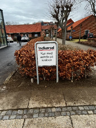 Facadeskilt monteret på erhvervsfacade med logo og virksomhedsnavn