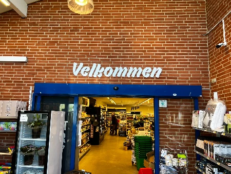Stort facadeskilt med logo monteret på erhvervsbygning